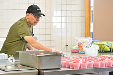 Food services staff prepare fruit cups for opening breakfast on Aug 3,2023.