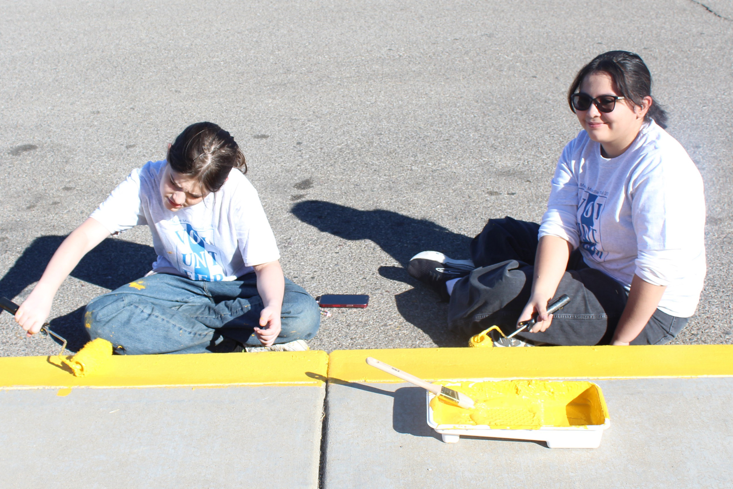 Students repaint the curb with yellow paint