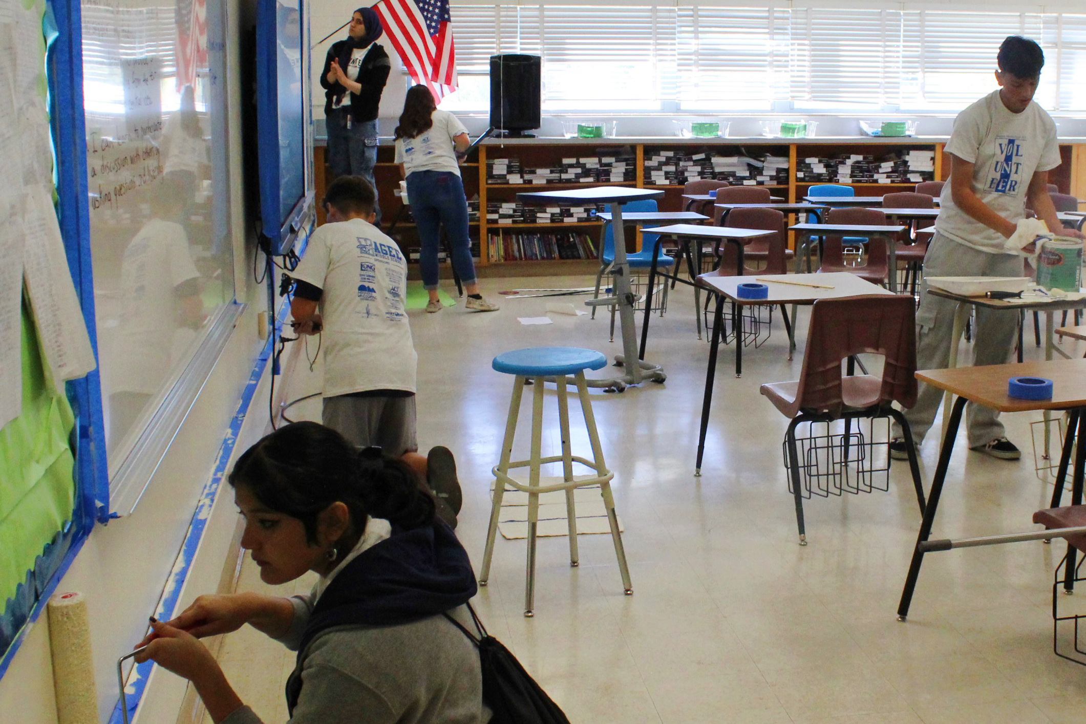 Students repaint the walls in a classroom