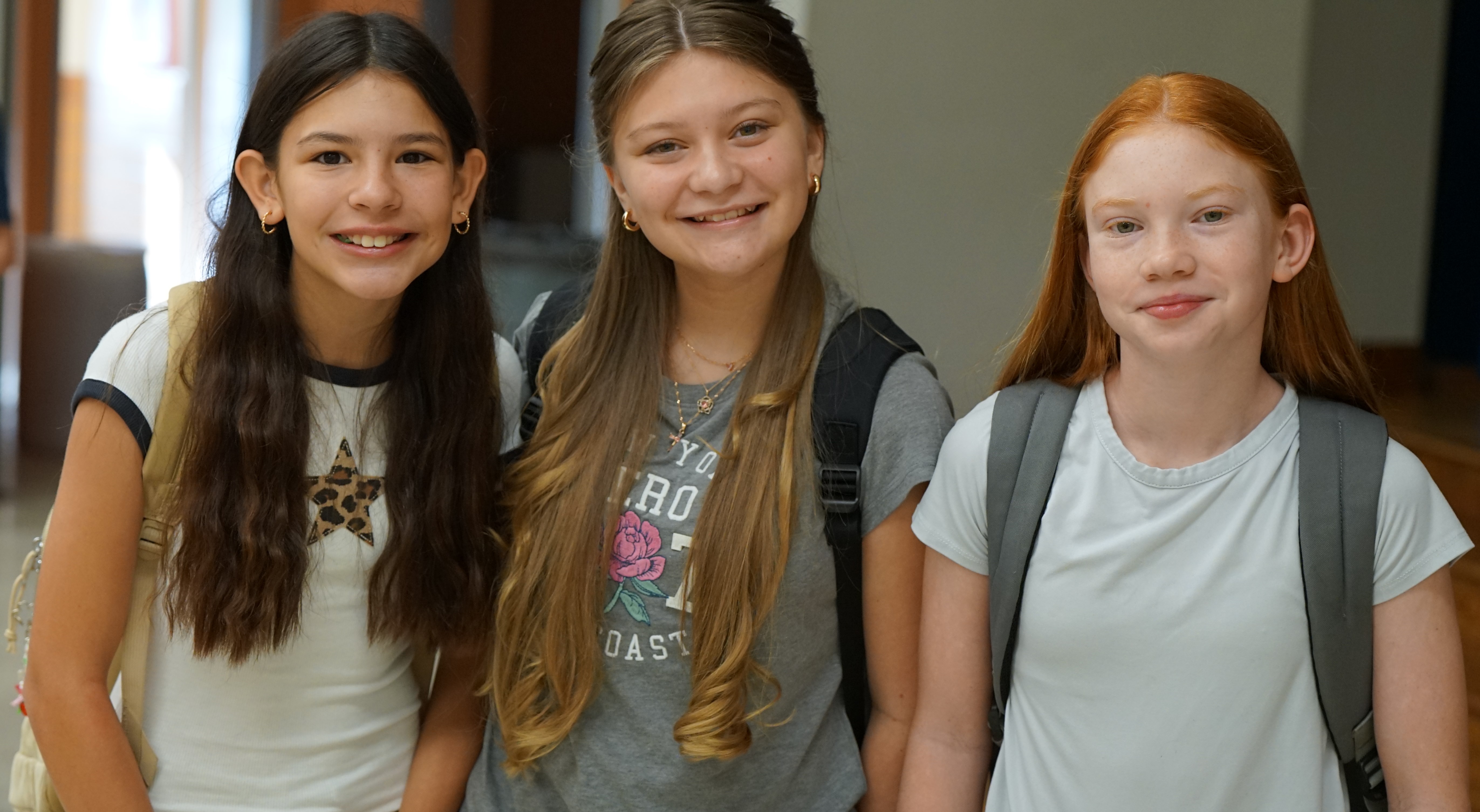 Three girls smile on the first day of school