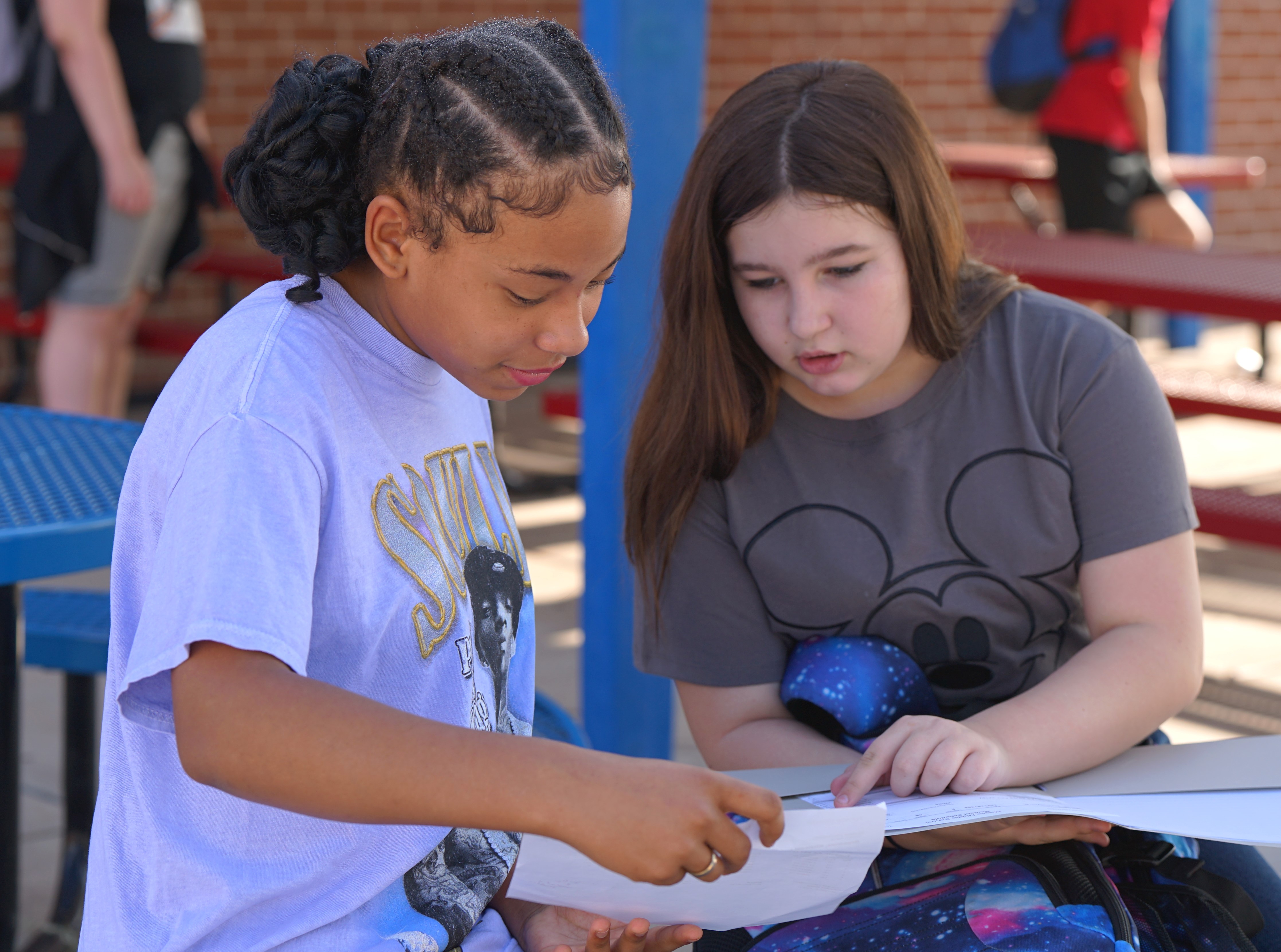 Two girls look over an assignment outside on the first day